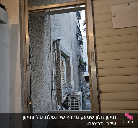 חלון עם תריסים פתוחים ומבנה חיצוני